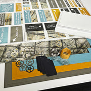 Collection of greeting cards, ribbons, and decorative items on a surface with a map design.