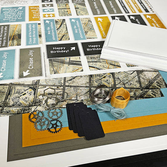 Collection of greeting cards, ribbons, and decorative items on a surface with a map design.